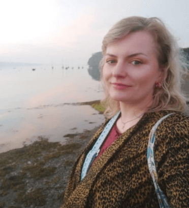 Gosia takes a selfie on the pebbly sea front in Y Felinheli at dusk.